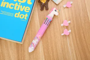 Vue détaillée d'un stylo bille multicolore 10 en 1 avec un joli topper licorne.