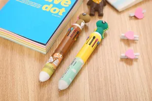 Vue détaillée des figurines de dinosaures et des boutons multicolores des stylos billes.