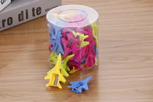 Close-up of colorful airplane shaped pencil sharpeners in a clear barrel container