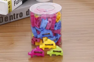 Detailed macro view of colorful dolphin-shaped pencil sharpeners in a clear display tub