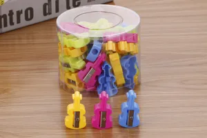 Violin shaped pencil sharpeners in colorful candy tones displayed in a clear tub.