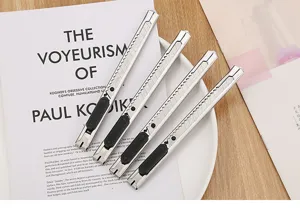 Set of four professional stainless steel utility knives on a minimalist white desk setup