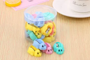 Macro detail of cute candy-colored turtle-shaped pencil sharpeners in a clear storage tub