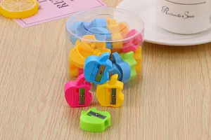 Close-up of apple-shaped candy color pencil sharpeners in a clear round container