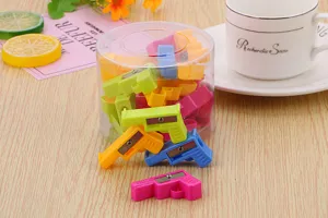 Close-up detail of cute colorful pistol-shaped pencil sharpeners stored in a clear container.