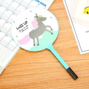 Cute cartoon unicorn fan ballpoint pen displayed on a wooden desk with a calendar backdrop