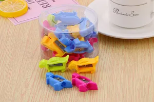 Selection of colorful cartoon dinosaur-shaped pencil sharpeners in a clear desktop container