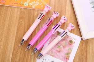 Cute cartoon 6-color ballpoint pens with pink pig toppers on a wooden desk
