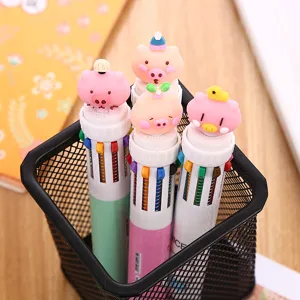 Primo piano di simpatiche penne a sfera multicolori a forma di maiale in un portapenne nero