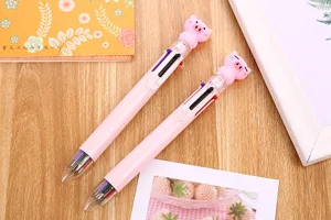 Detailed view of two cute pink multi-color ballpoint pens with cartoon pig toppers