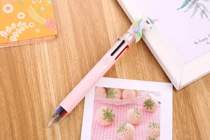 Detail macro view of cute pink multi-color ballpoint pen with unicorn topper