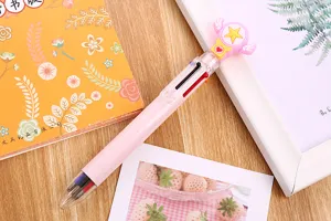Close-up of a pink multi-color ballpoint pen featuring a cute cartoon star and wing design.