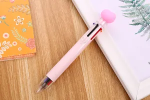 Detailed close-up view of a pink 6-in-1 multicolor ballpoint pen with heart topper