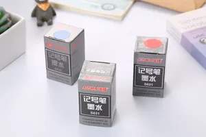 Primer plano detallado de cajas de tinta para rotulador permanente negro, rojo y azul.