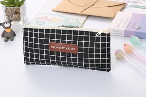Close-up detail of black grid oxford fabric pencil case with central brand patch