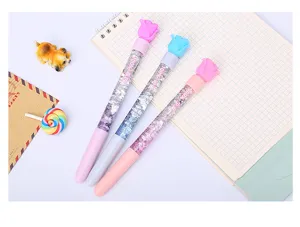 Vista dettagliata di penne creative con sabbie mobili, rose di gomma e paillettes