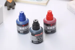Tres botellas de tinta para marcador permanente en negro rojo y azul sobre fondo blanco.