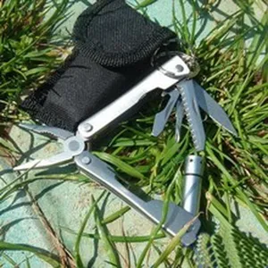 Vue detaillee de la pince multitoutil en acier inoxydable avec pochette noire, en exterieur.