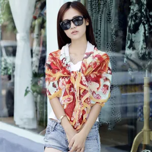 Bloemen chiffon zonnebrand sjaal met parel gesp gedragen door een model in de zon