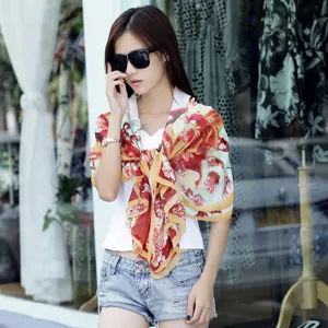 Gedetailleerd overzicht van een elegante chiffon sjaal met bloemenprint voor het strand