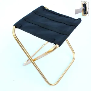 Detail shot of portable folding camping stool, showing compact metal frame and fabric seat.