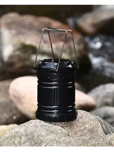 Detailopname van een zwarte uitschuifbare outdoor campinglamp geplaatst op natuurlijke rotsen.