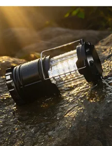 Detail draagbare LED campinglantaarn op natte rots, heldere verlichting voor buiten.