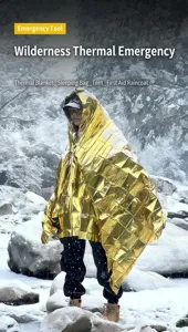 Detalle de la manta térmica de emergencia dorada de Mylar utilizada en entorno invernal nevado.