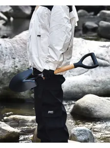 Utensile da campeggio all'aperto con manico in legno e robusta testa di pala nera.