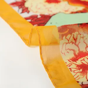 Detailopname van een transparante chiffon strandsjaal met een levendige bloemenprint