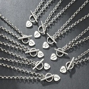 Silver tone toggle clasp necklace featuring initial letter heart pendant detailed closeup shot.