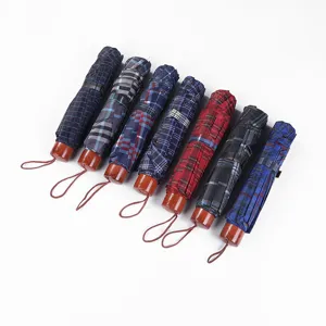 Classic plaid three-folding umbrella with wooden handle, portable and stylish compact rain gear.