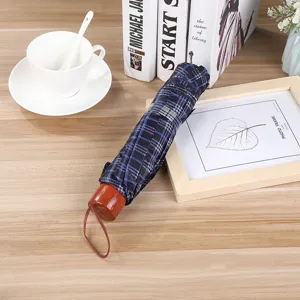 Compact 3-folding umbrella with stylish blue plaid pattern and classic wooden handle design.