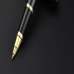 Close-up detail of luxury business metal rollerball pen with black body and gold trim.