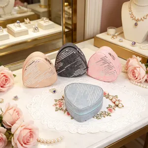 Detailed view of denim sequin heart-shaped jewelry boxes in pink, blue, grey, and beige.