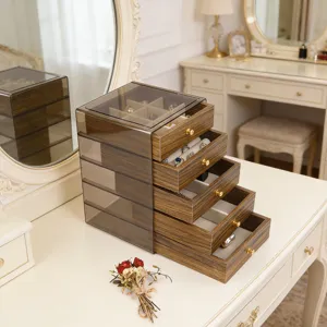 Detailed view of wood grain jewelry box with acrylic lid and four gold-handle drawers