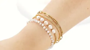 Gros plan détaillé de l'ensemble de bracelets de perles et perles dorées empilées
