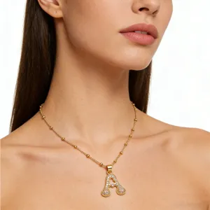 Close-up view of the rhinestone letter heart pendant necklace on model neck detail shot.