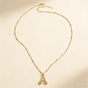 Detailed view of a gold-colored letter A pendant necklace with sparkling cubic zirconia.
