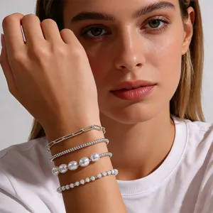 Ensemble de bracelets superposés avec chaînes trombone, perles et maillons argentés.
