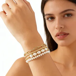 Gros plan détaillé de bracelets multi-rangs en chaîne dorée et perles d'eau douce.