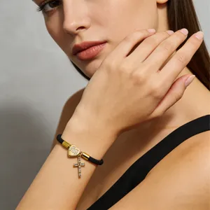 Primo piano dettagliato del elegante bracciale in corda nera con ciondolo a cuore e croce.