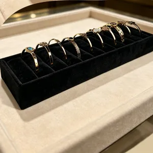 Detail view of a black velvet 10-slot rectangular jewelry display tray for bracelets.