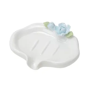 White ceramic soap dish with blue flower decor, drainage spout for bathroom and home use.