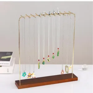 Detailed view of large wooden necklace display stand with multiple gold hanging hooks