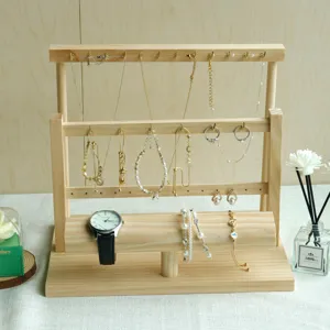Detail view of a three-tier solid wood jewelry organizer showing necklaces and a watch.