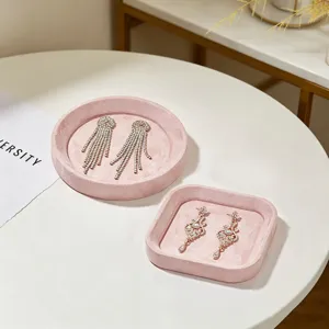 Gedetailleerd overzicht van roze fluwelen sieradentrays met elegante oorbellen op tafel