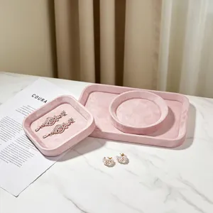 Macrodetail van elegante roze fluwelen sieradentrays voor ringen en oorbellen op marmer