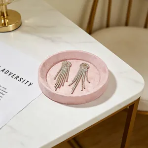 Elegante roze fluwelen sieradenschaal met oorbellen getoond op een marmeren tafelblad