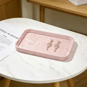 Close-up van een luxe roze fluwelen sieradentray met oorbellen op marmeren tafel